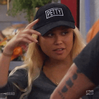 a girl with blonde hair pulls down a ball cap that says "Petty" over her face