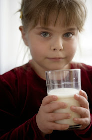 Lovely kid drinks a glass of milk