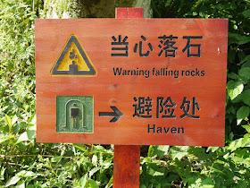 Sign with a falling rocks warning and directions to a "haven"