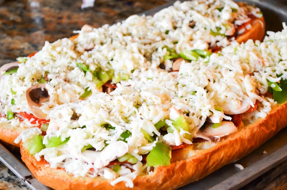French Bread Pizza covered with cheese and a light dusting of Italian Seasoning.
