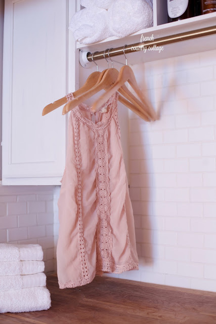 Blush shirt drying on laundry room clothes rack Subway tile laundry room