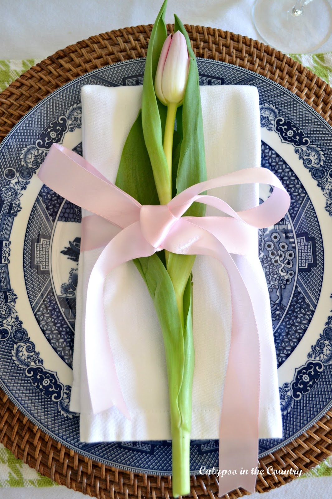 Pink tulip stem on blue and white porcelain plate