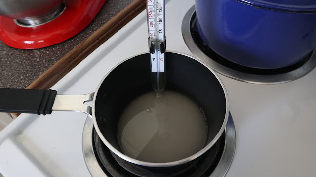heating up of the sugar mixture in a small pot with a candy thermometer on the stove