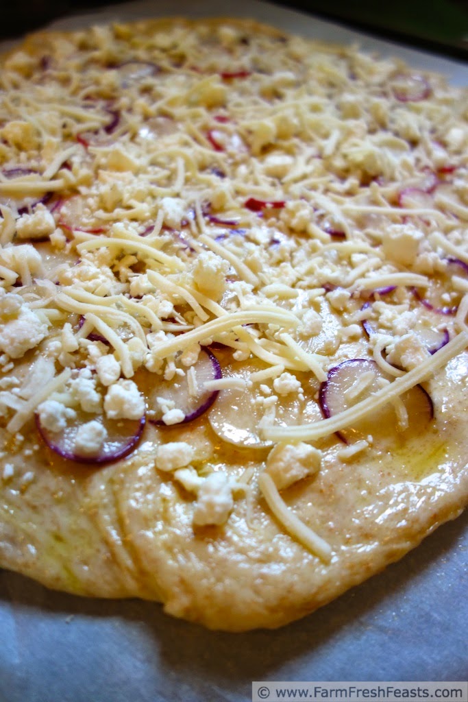 Thinly sliced radishes with feta, goat cheese, and shredded cheeses in a spring radish pizza.