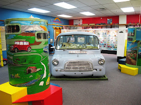 Old Bedford van in the middle of a museum room.