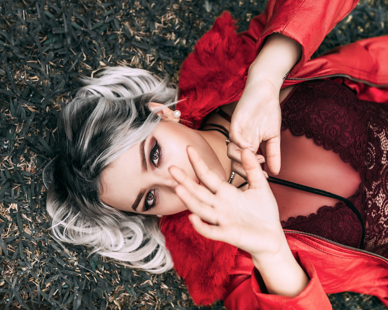 girl with silver hair lays on the grass