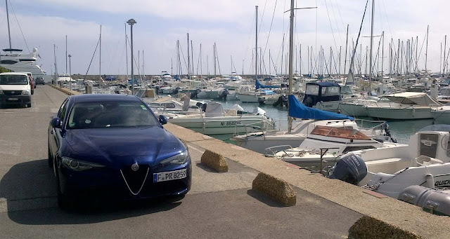 Alfa Romeo Giulia im Hafen von Saint Laurent du Var, Segeljollen, kleine Boote, Mole und andere Autos im Hintergrund