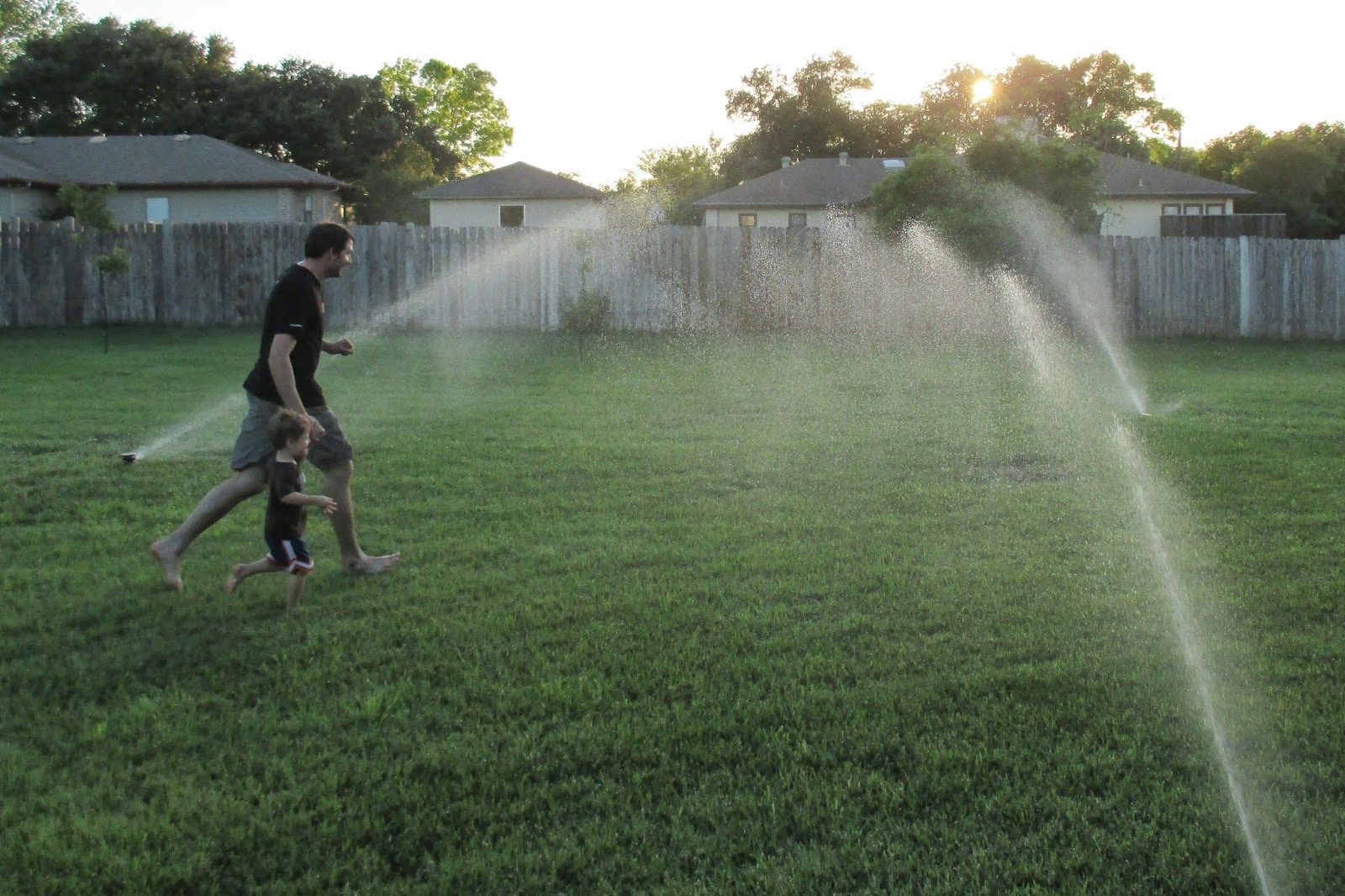 Joyful Family Life Running through sprinklers