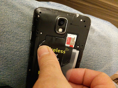 Hold the Contacts Down in Place while Taping the Card to the Battery, If you Choose to do so. I am holding the contacts down as I tape the right edge of the Qi coil receiver module card down.