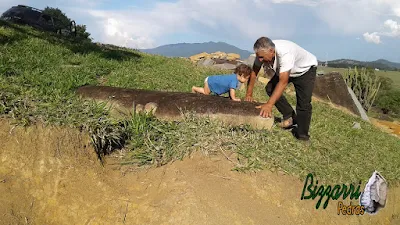 Bizzarri, com o neto, fazendo o que mais gosta, garimpando pedras para fazer as construções com pedras. Na foto garimpando pedras para execução de ponte de pedra e pedras para paisagismo. Na foto uma pedra ornamental de 2,30 m de comprimento por média de 1,00 m de largura por 20 cm de espessura. Gosto de garimpar esses pedras ornamentais pois já vou imaginando elas em cada trabalho com pedra que vou executando.