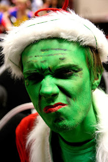 Picture of scowling green faced man in hand made Grinch costume 