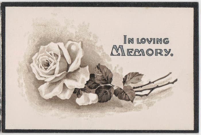 Black bordered off white card, image of a white rose and words "In Loving Memory"
