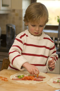 young boy making wraps for after-school snack