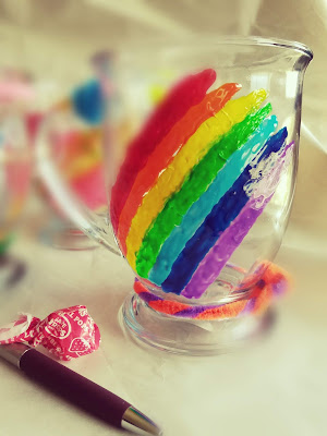 A decorated glass mug with rainbow colors