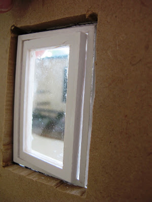 Close up of the Inside of a half-built dolls' house shed, showing that the windows don't fit the full depth of the wall.