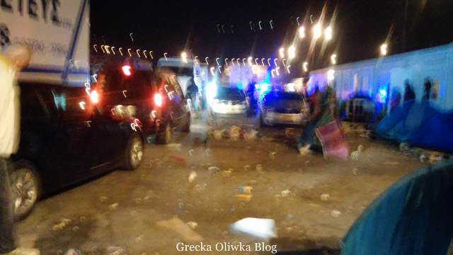 Ludzie nie dzielą się na dobrych i złych; pieniądz rządzi światem, po prostu. nocny widok w porcie Vathi Samos Grecja, śmieci, namioty uchodźców,