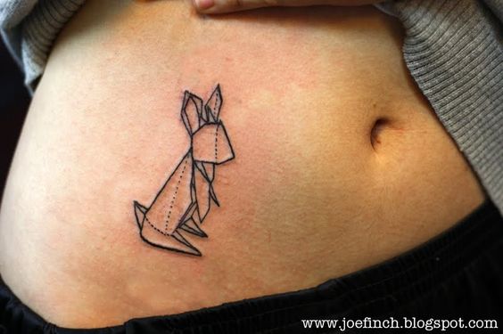 vemos el estomago de una chica, lleva un tatuaje de conejo origami