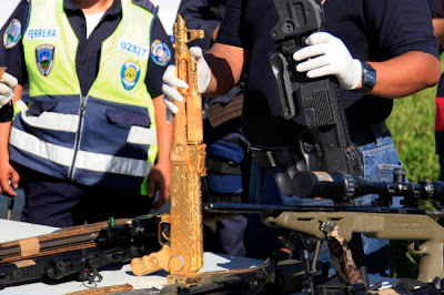 SEORANG anggota polis menunjukkan selaras senjata api AK-47 bersalut emas yang dihiasi batu berlian dan zamrud di Ciudad Jardin de Choloma pada Sabtu lalu.