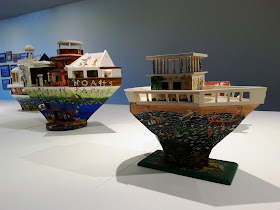 Two miniature wooden painted artist's arks on display in a gallery.