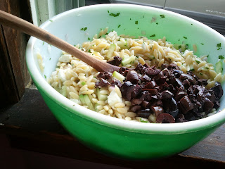 Orzo salad with addition of kalamata olives, ready to be combined.