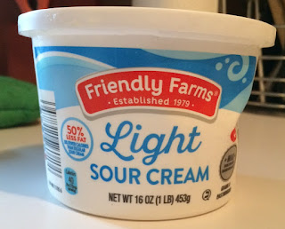 A closed tub of Friendly Farms Light Sour Cream, from Aldi