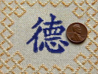 Detail of "virtue" Chinese character block, with penny shown for scale