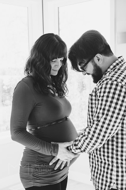 Black and white photo of couple expecting first child taken by Melanie Mathieu Photography during home photo session in Gatineau QC