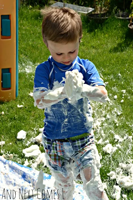 Kid covered in shaving cream playing outdoors