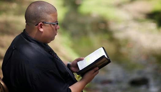Héctor "El Father" leyendo biblia