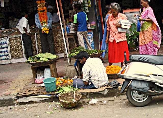 man selling flowers on pavement