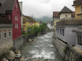 Buildings line a channel flowing with rushing waters, Andermatt, Switzerland