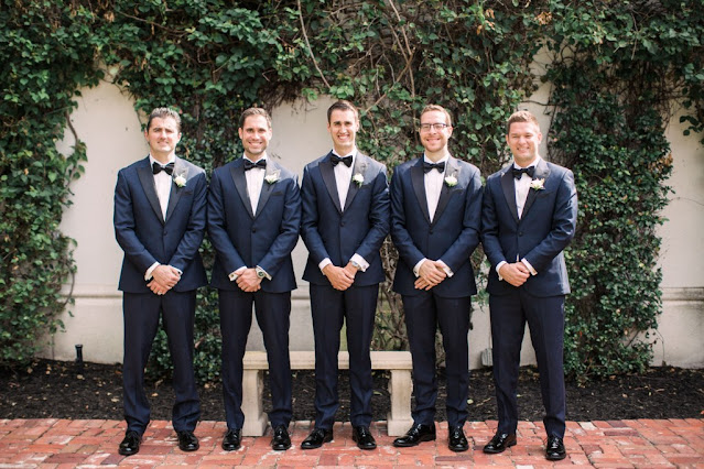 groomsmen smiling in tuxedos