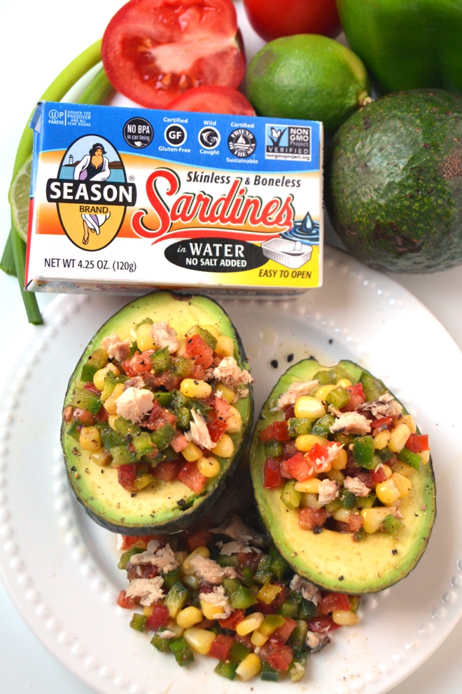 Mexican Sardine Salad Stuffed Avocados features a sardine salad made with tomatoes, bell peppers, corn and green onion with a tangy vinaigrette stuffed in a ripe avocado for an easy, nutritious meal! www.nutritionistreviews.com