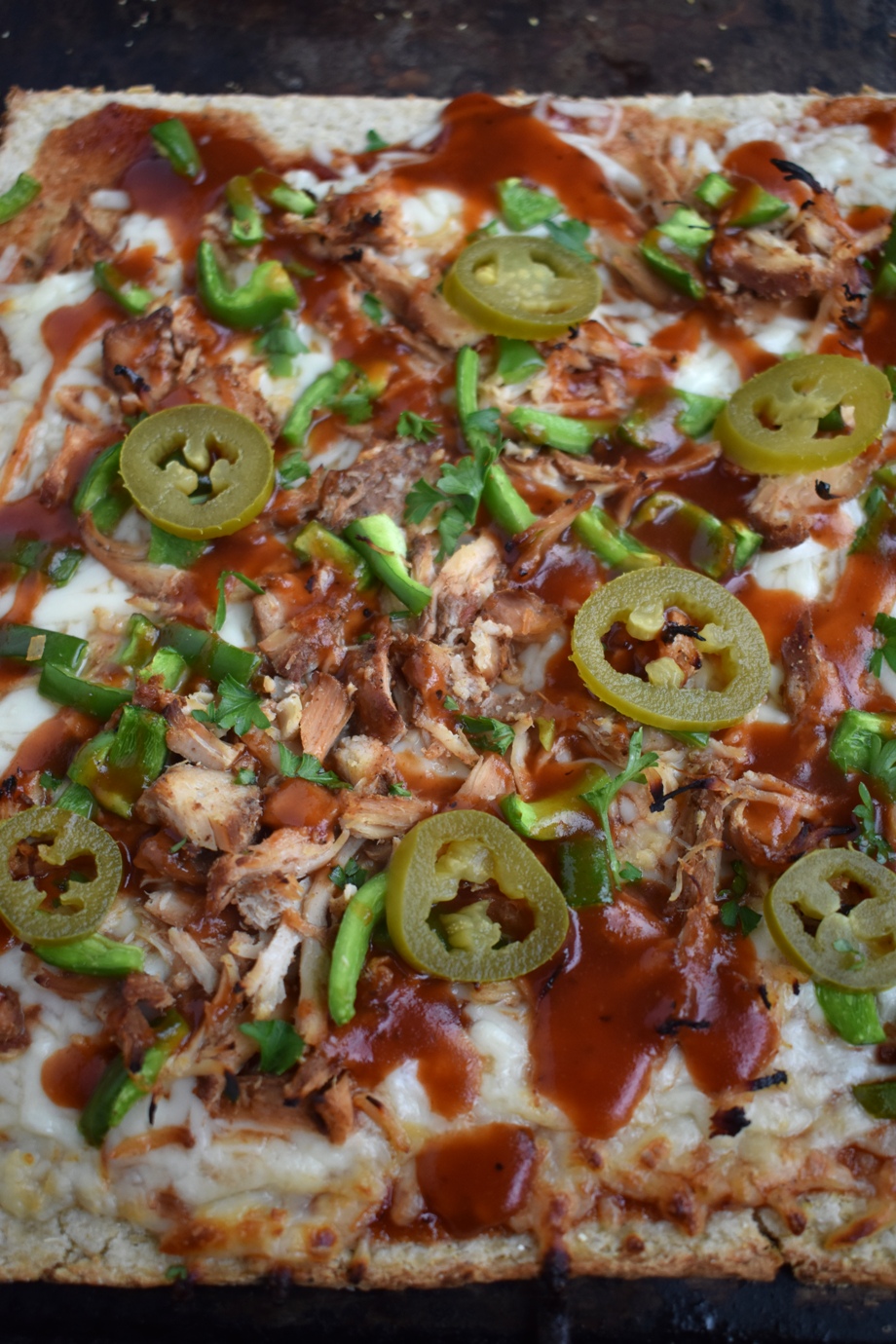 BBQ Chicken Pizza with Cauliflower Crust is nutritious with an 80% cauliflower crust and is topped with shredded chicken, BBQ sauce, mozzarella cheese, bell peppers and jalapenos! www.nutritionistreviews.com #pizza #bbq #cauliflower #healthier #dinner