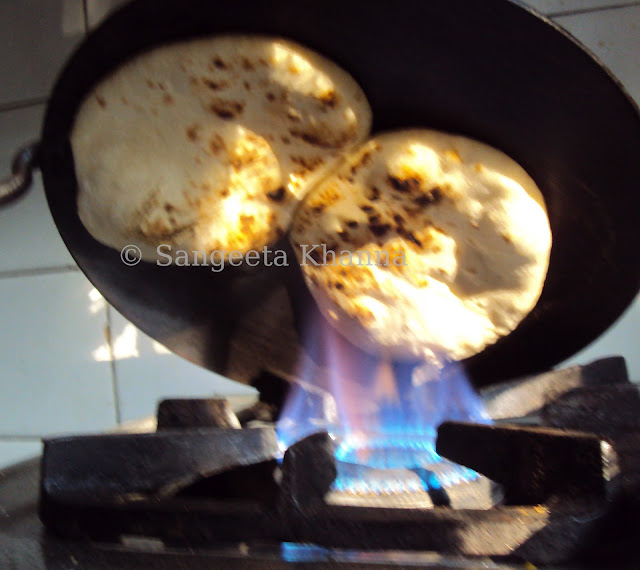 whole wheat naan being baked on griddle 