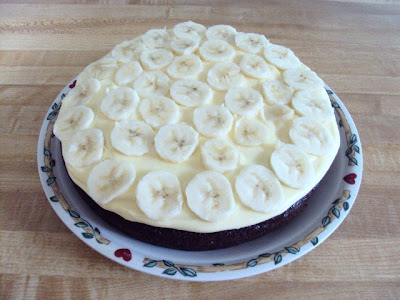 Moist chocolate cake with a touch of banana, vanilla cream and fudge drizzle!Moist chocolate cake with a touch of banana, vanilla cream and fudge drizzle!