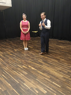 Photo of people dressed in 1940s vintage style preparing for a swing dance (Lindy Hop) class.