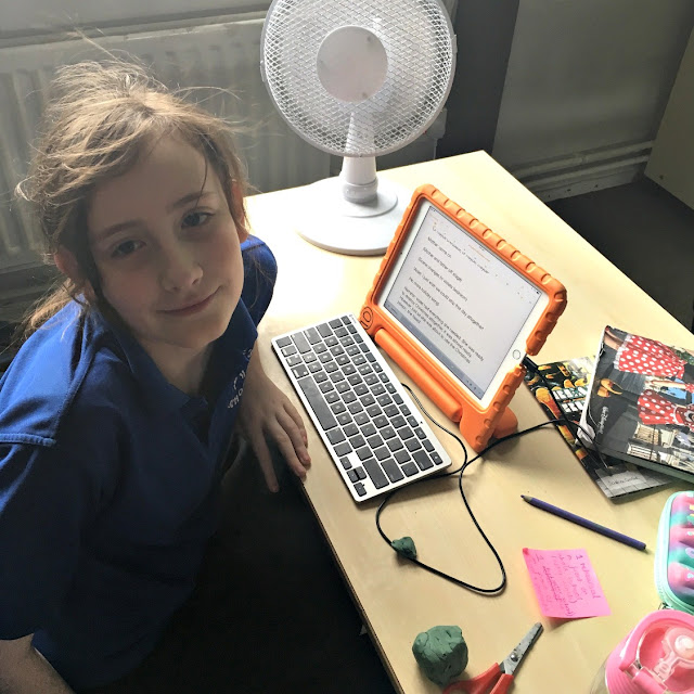 Sasha at school desk with fan