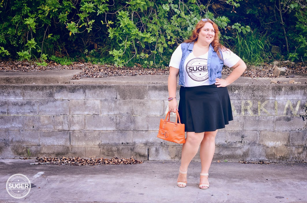 Melissa from Suger Coat It blog wearing denim vest over yellow tee and short black skirt