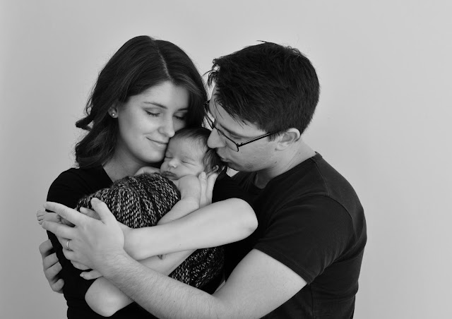 mom dad and sleeping newborn baby photography