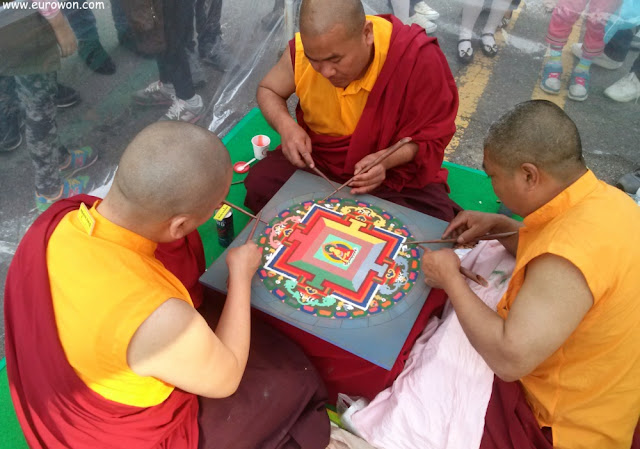 Monjes tibetanos dibujando ofrenda a Buda
