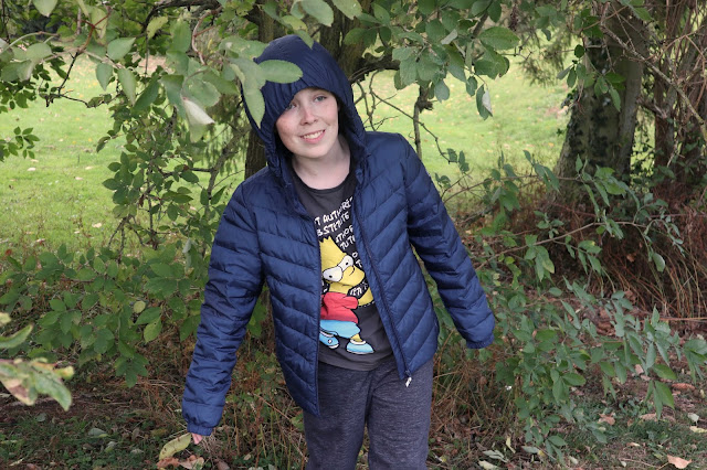 Boy standing in some trees wearing a Reima Falk Boys Jacket
