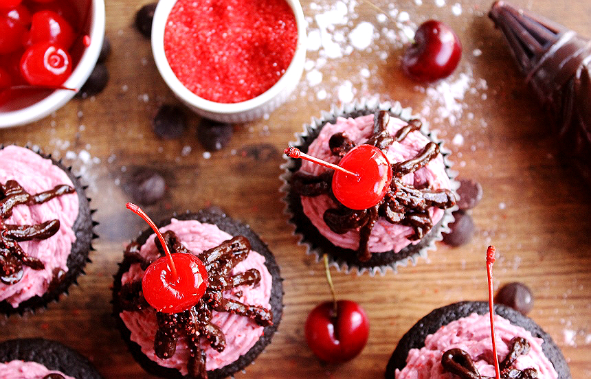 Chocolate Covered Cherry Cupcakes- A Decadent Moist Devil's Food Cake infused with Tart Cherry Juice, topped with a Creamy Tart Cherry Buttercream Frosting, and Drizzled with a Rich Chocolate Ganache.
