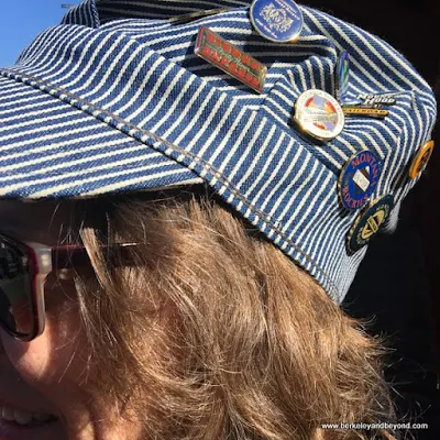 Ginger Dingus wears her engineer's hat with pins from prior train trips,  at Railtown 1897 State Historic Park in Jamestown, California