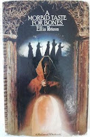 A Morbid Taste for Bones by Ellis Peters The book cover features the ghostly image a St. Winifred in the foreground with Brother Cadfael under an arch behind her and a line of five monks in the background.