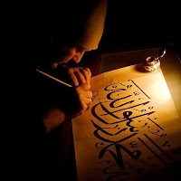Bir hattat mum ışığında Arapça hat yazarken