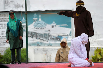 A Muslim woman is caned in Banda Aceh, Indonesia, for breaking sharia law.