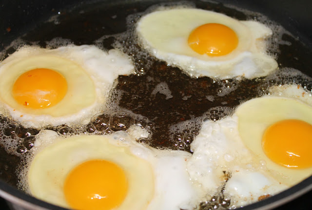Eggs frying in bacon fat. Frying Eggs