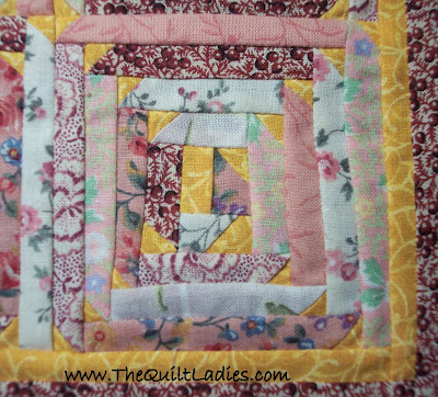 Pink Log cabin quilt with triangle corners
