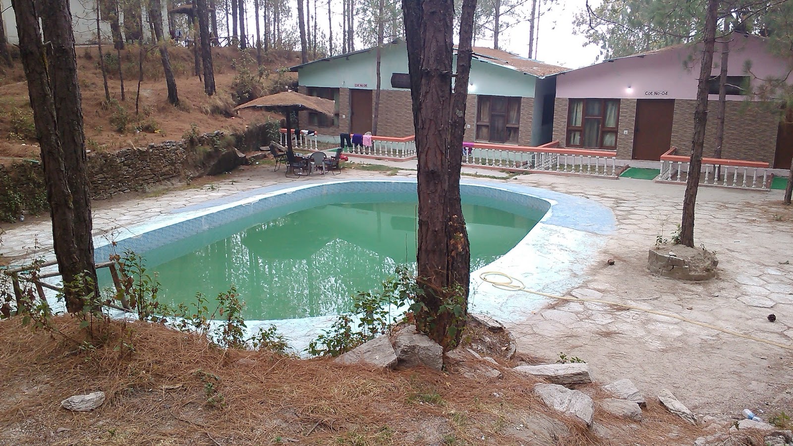 The swimming pool and cottages at the Retreat Anand Jungle Resort in Lansdowne
